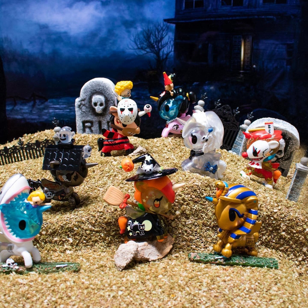 A group of tokidoki Unicorno After Dark Series 2 Blind Box figurines in a pile of sand.