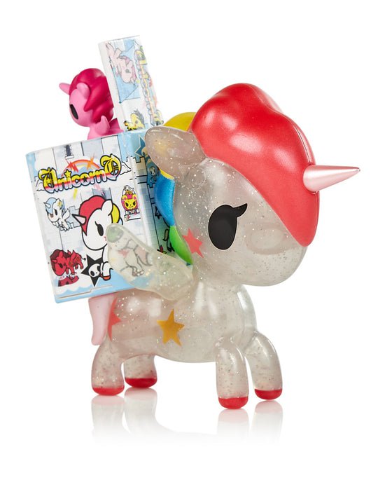 A limited edition tokidoki Unicorno Stellina BB Limited Edition Figure is holding a book.